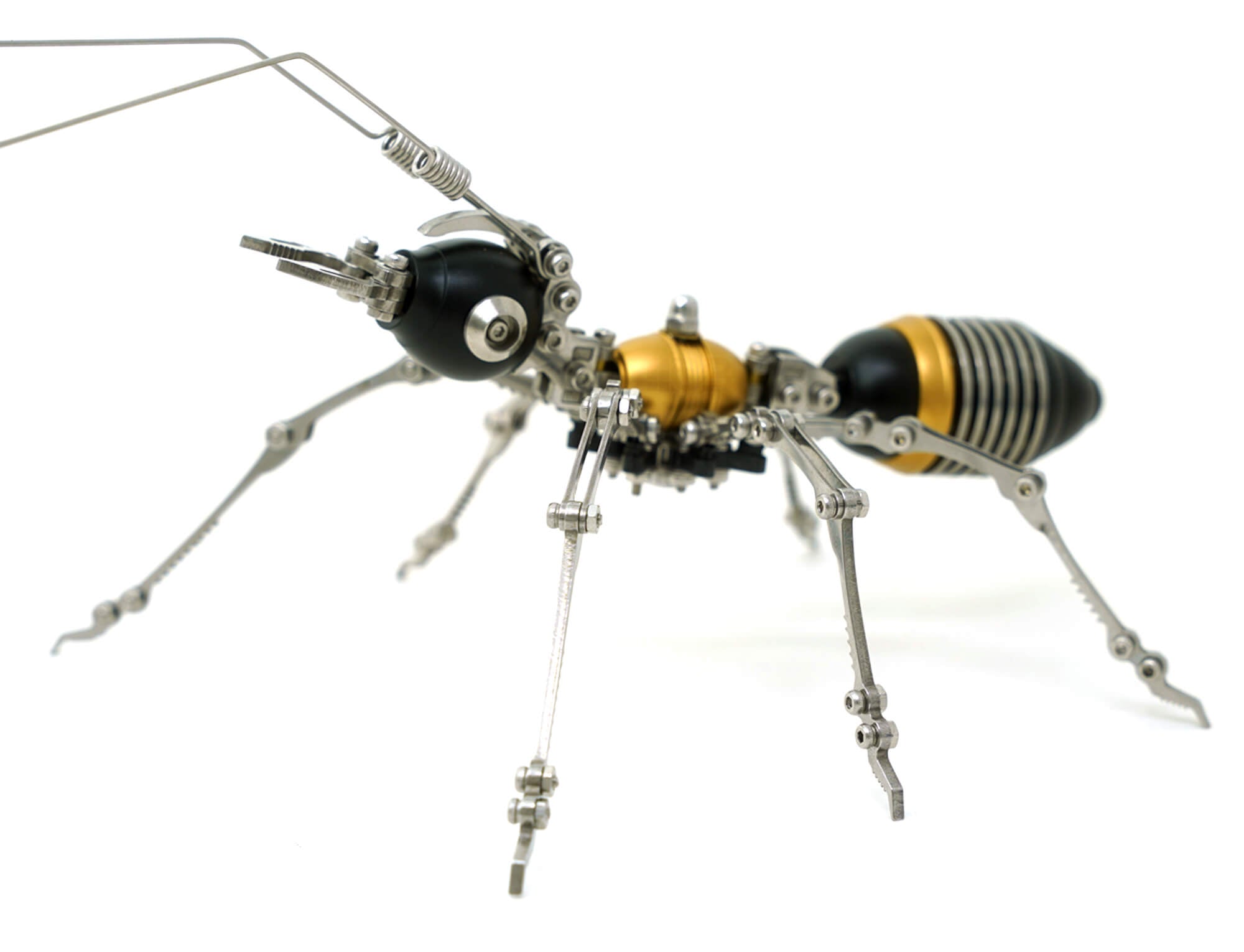 Formiga mecânica articulada 3D montada em metal, vista lateral, acabamento preto e dourado