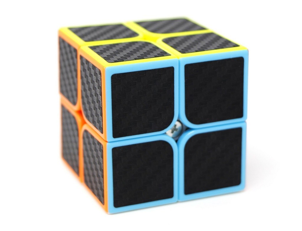 QiYi QiDi Carbon 2x2 montado sobre superfície branca, destacando o visual elegante com textura carbon