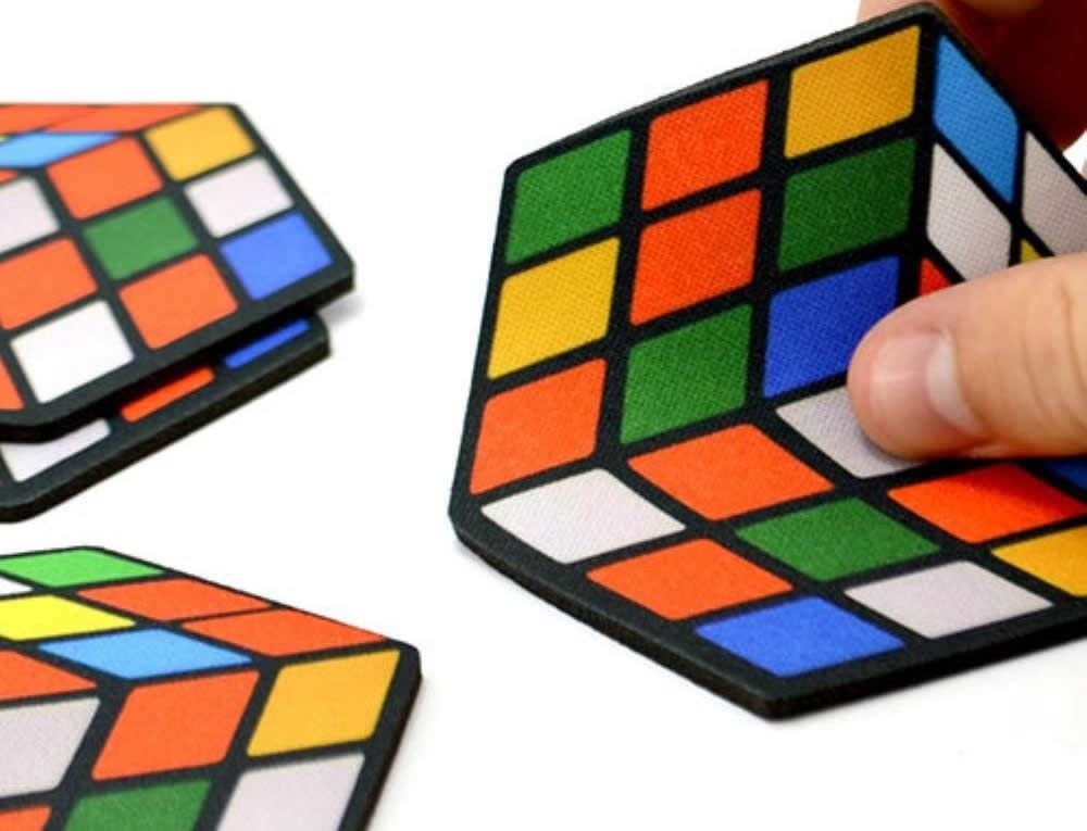 Detalhe dos porta-copos de Cubo Mágico empilhados mostrando os lados coloridos
