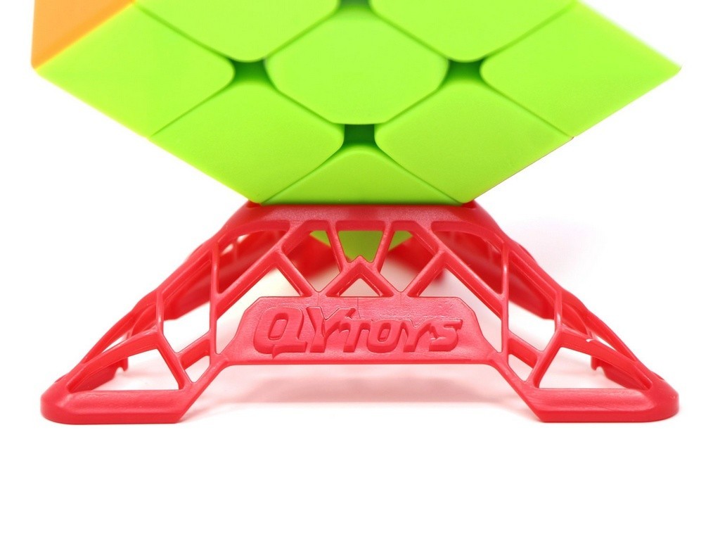 Vista lateral da base expositora DNA QiYi vermelha apoiando um Cubo Mágico 3x3