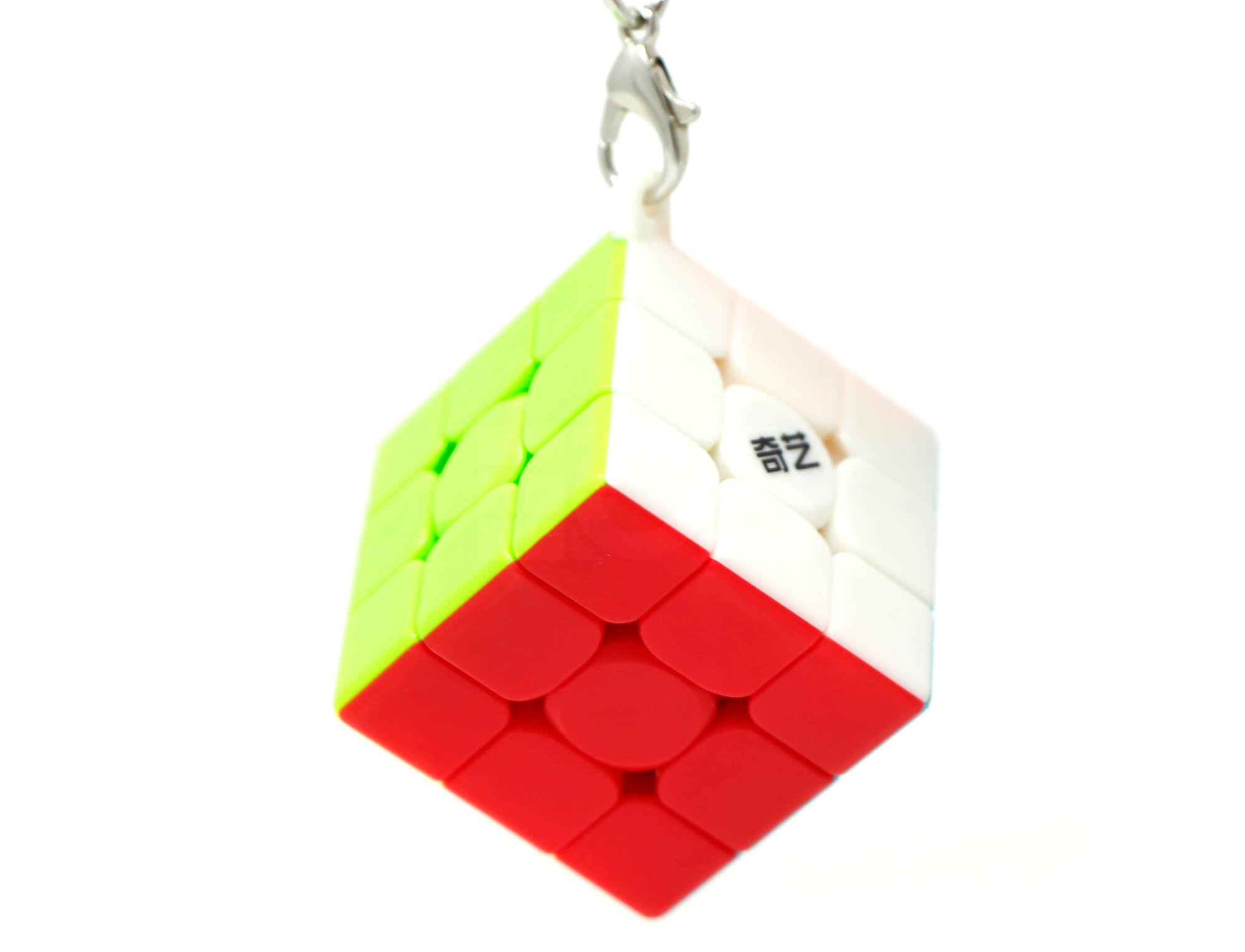 Cubo Mágico 3x3 chaveiro QiYi ao lado de uma mochila ilustrando o uso portátil